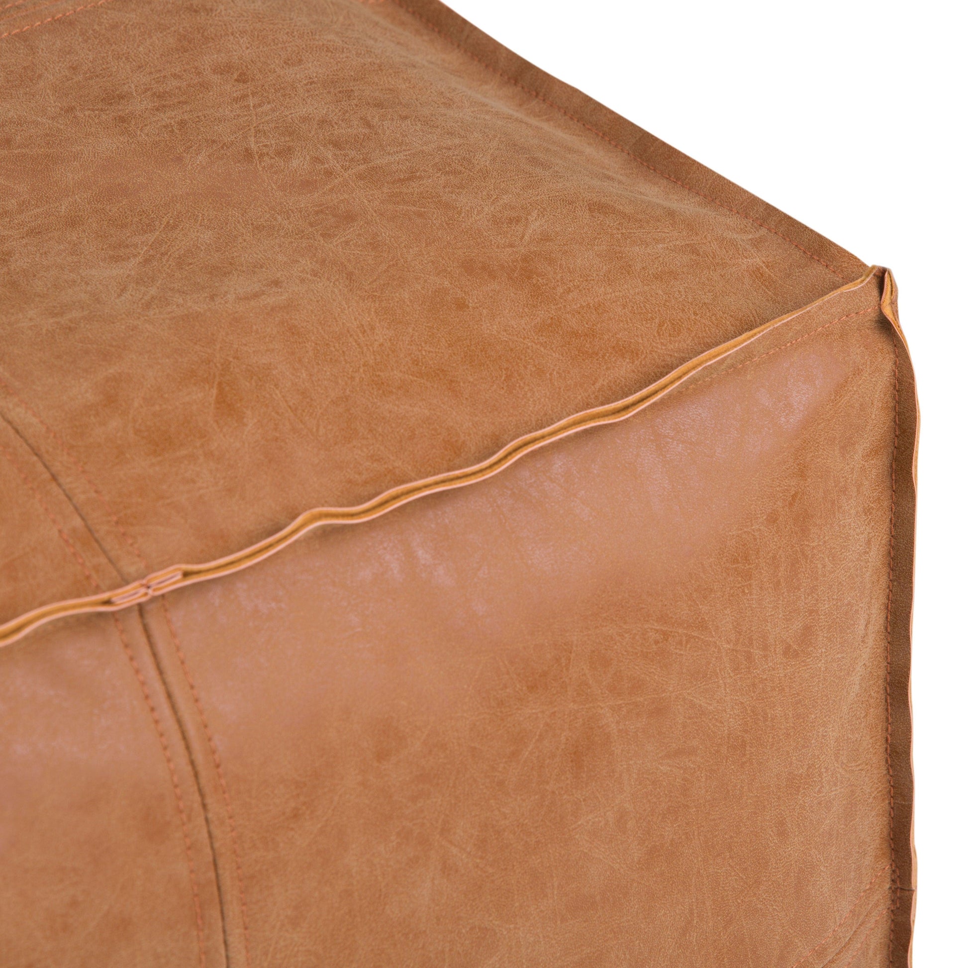 Close-up of the Brody - Versatile Square Pouf in brown leather, highlighting its textured surface, detailed stitching, and piping along the edges.