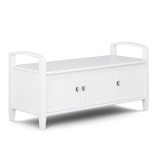 The Warm Shaker Handcrafted Entryway Storage Bench is a white wooden indoor bench with armrests, three doors with silver handles, providing both seating and storage.