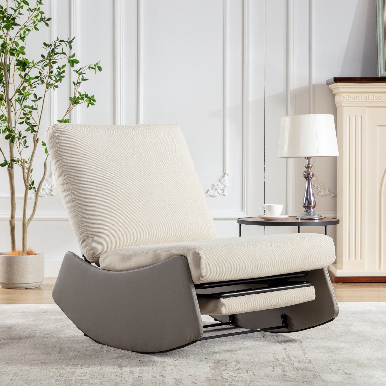 A Modern Rocking Chair Recliner with footrest and soft padding sits in a bright living room beside a round table with lamp and cup, a fireplace, potted plant, and decorative wall molding. Ideal as an accent lounge or nursery chair for relaxing.
