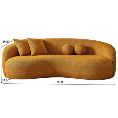 The Drake Japandi Style Curvy Boucle Sofa in mustard yellow features a plush texture, two rectangular and two round cushions, and measures 89"W x 31"D x 45"H, shown with black arrows and text.
