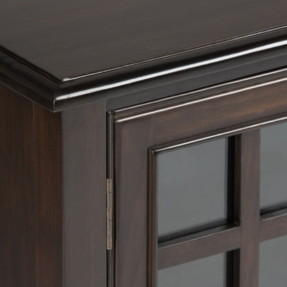 Close-up of the top corner of the Connaught - Handcrafted Low Storage Cabinet, featuring dark wood, glass-paneled doors, decorative trim, visible hinge, and a smooth finish.