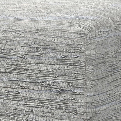 Close-up of the textured, light gray woven fabric covering the corner of the Fredrik - Handcrafted Square Pouf, showcasing its layered and slightly rough pattern.