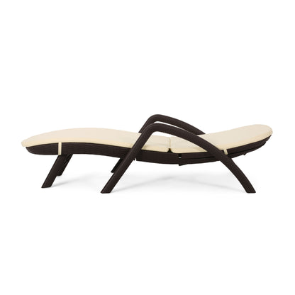 The Mikael - Chaise Lounge With Cushion features a modern dark brown wicker frame and a cream cushion, displayed in profile against a white background.