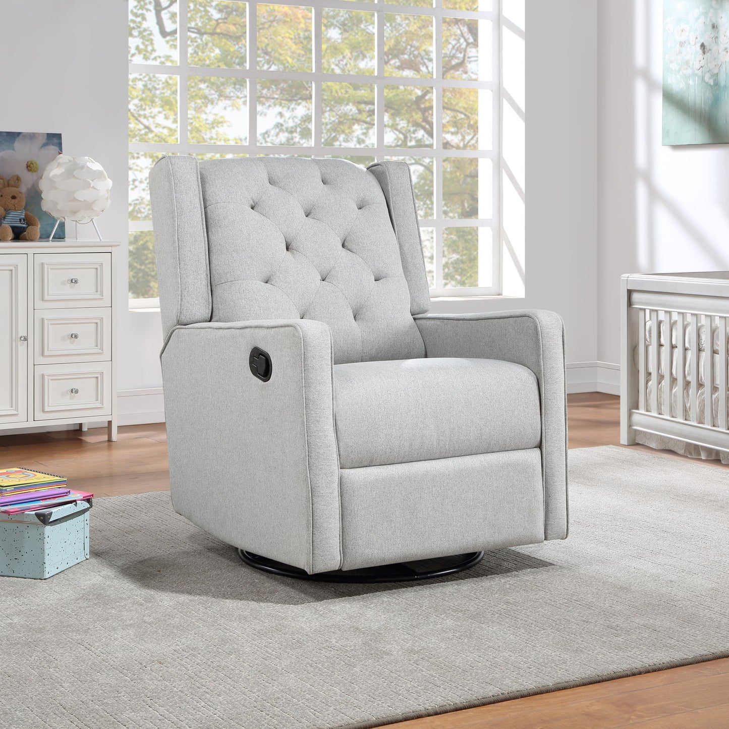 The Milah - Gliding Swivel Recliner Tufted in light gray sits on a gray rug in a bright, modern room with large windows, white furniture, and wooden floors.