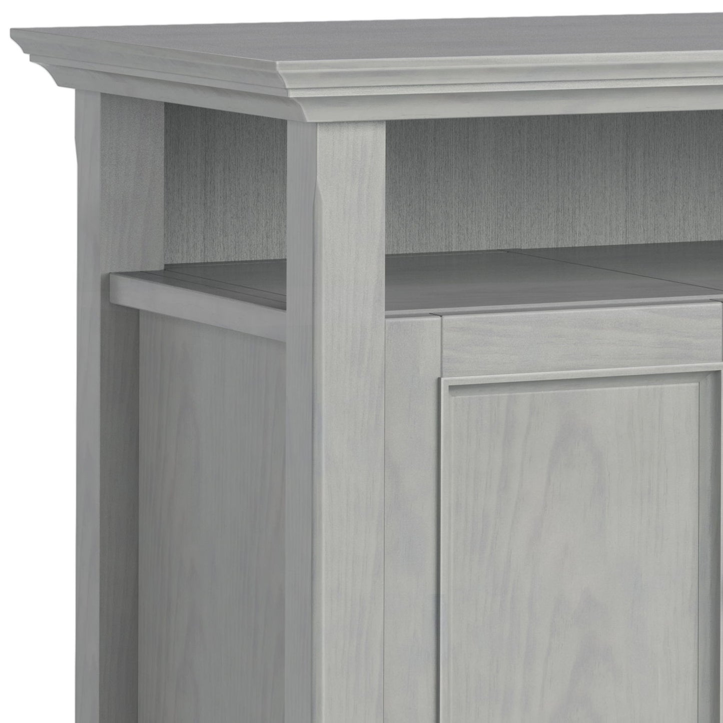 Close-up of the top corner of the Amherst - TV Media Stand, Handcrafted, showcasing its light gray finish, decorative trim, vertical paneling, and open shelf above the cabinet door.