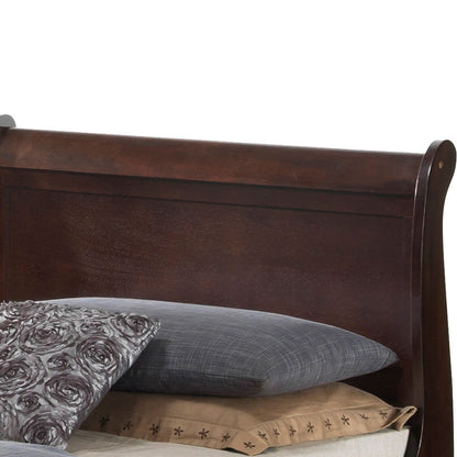 The Louis Phillipe - Storage Bed features a dark wooden sleigh-style headboard with a brown finish, partially visible behind stacked pillows and bedding in gray, floral, and beige patterns.