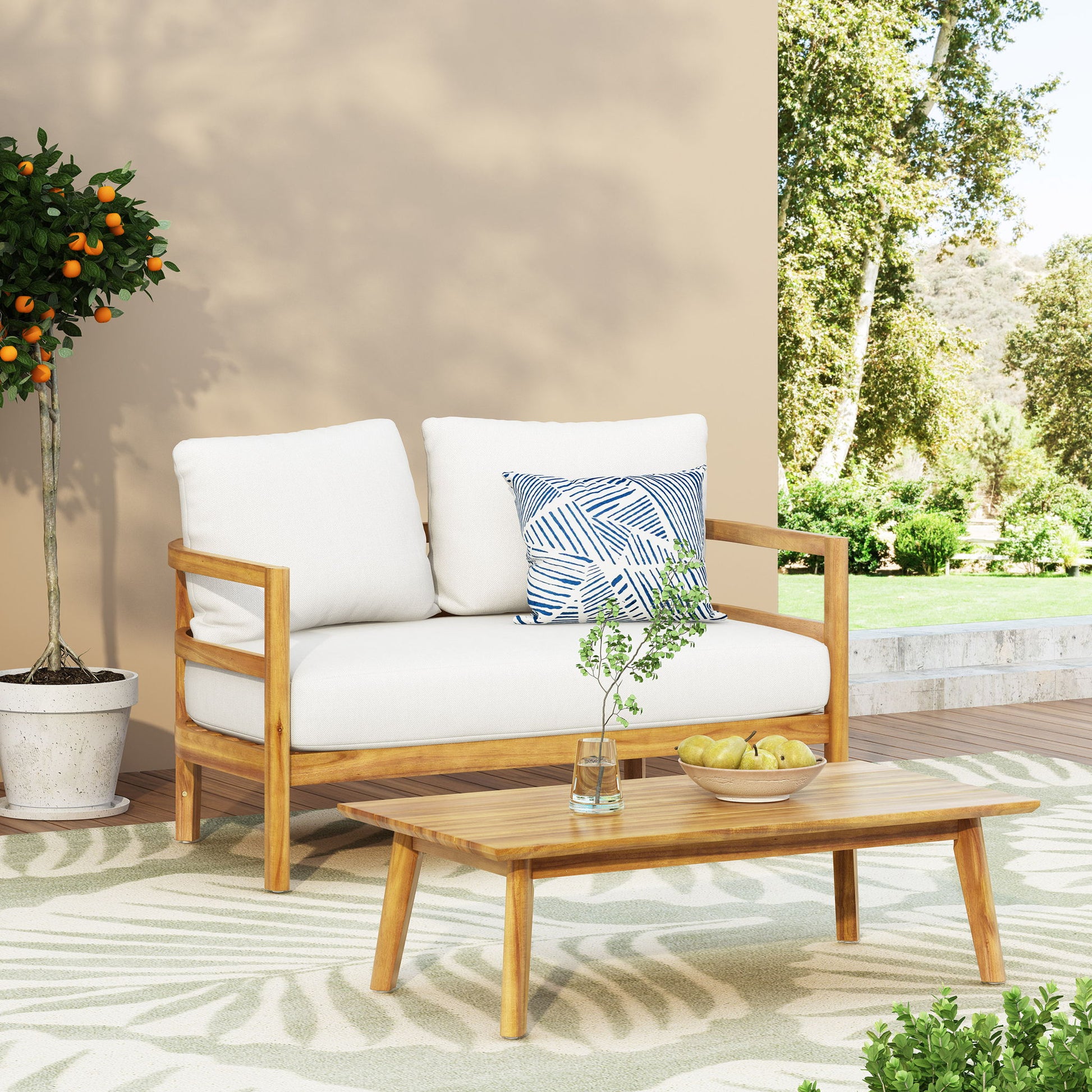 The Outdoor Furniture With Coffee Table, Patio Conversation Set Deep Seating With Soft Cushion is arranged on a patio near a potted orange tree, with lush greenery in the background and a glass vase and apples on the coffee table.