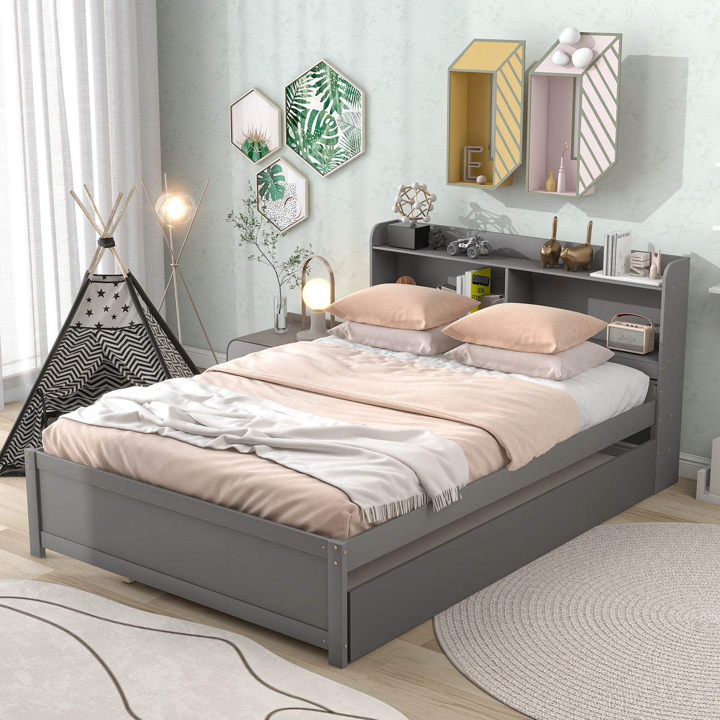 A modern bedroom with a gray Full Bed With Trundle, Bookcase headboard, blush pink and white bedding, decorative mirrors, wall art, a small teepee, and soft natural light from a window with white curtains.