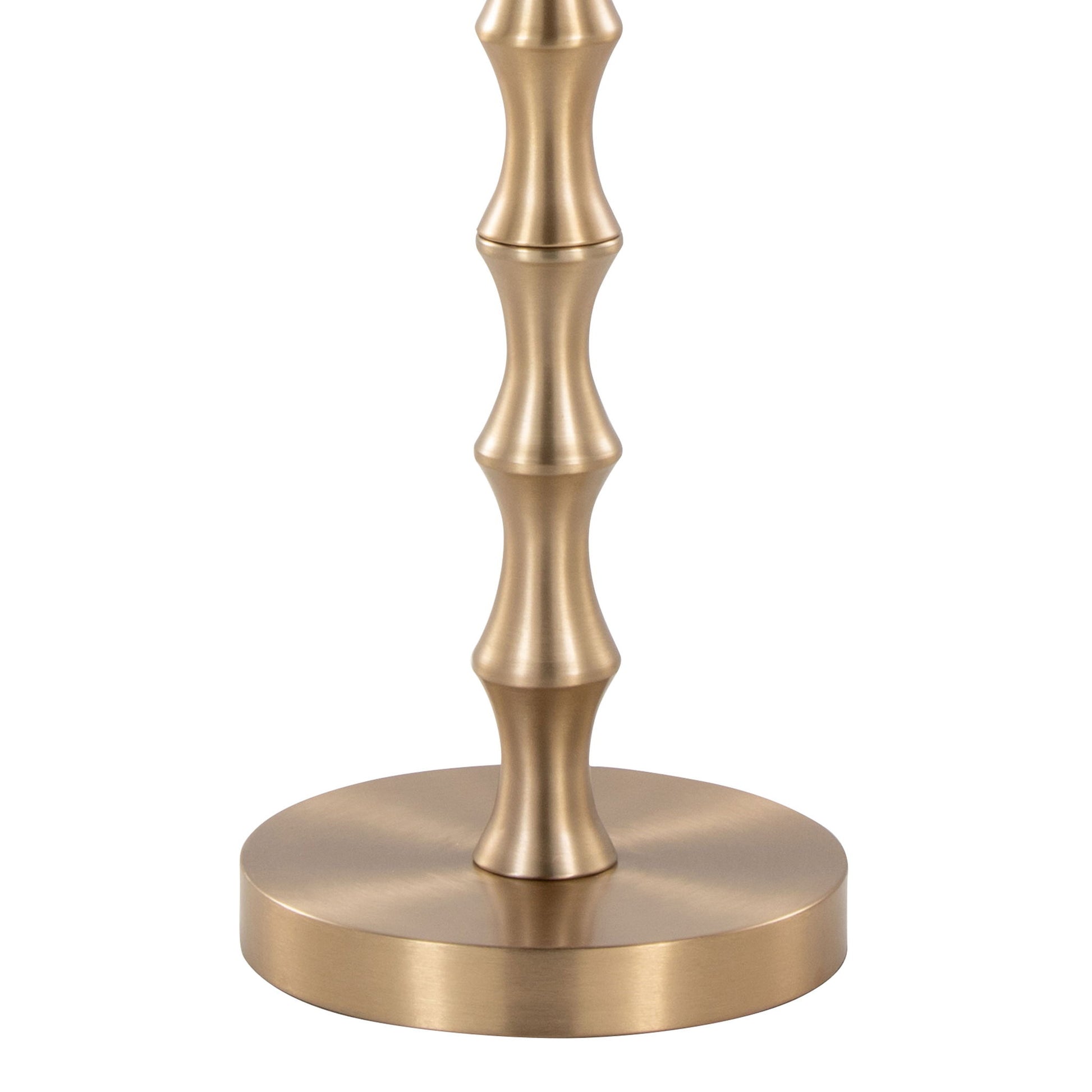 The Bora - Contemporary Table features a metallic base with a brushed gold finish and rounded, ribbed accents inspired by bamboo, resting on a circular platform.