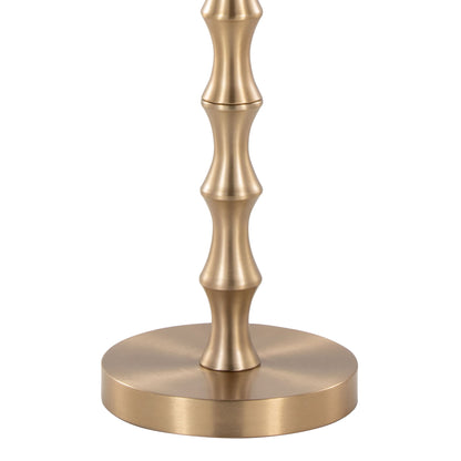 The Bora - Contemporary Table features a metallic base with a brushed gold finish and rounded, ribbed accents inspired by bamboo, resting on a circular platform.