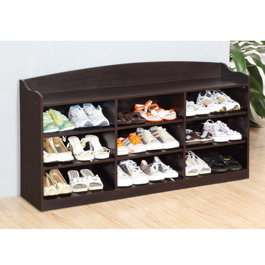 The Entryway Shoe Storage Bench with nine storage shelves is placed against a light wall on a wooden floor, each shelf holding different shoes. A leafy plant appears on the right, adding to the organized entryway look.