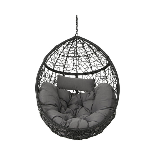 The Kylie Boho Style Hanging Basket Chair is black, egg-shaped, and made of rattan with thick dark gray water-resistant cushions and a headrest, suspended by a metal chain against a white background.