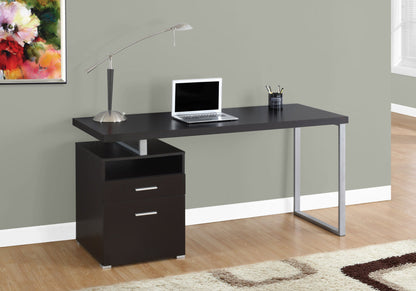 The Computer Desk For Home Office features storage drawers and a contemporary design. It holds a laptop, lamp, and pen holder on its surface, with a colorful painting above and part of a window and rug nearby on the wooden floor.