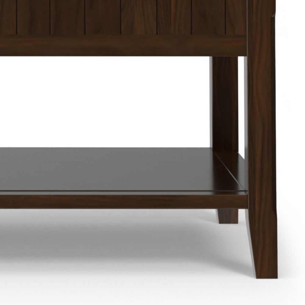 Close-up of the lower section of the Acadian - Lift Top Coffee Table in brown, featuring four legs, a flat lower shelf, and part of the vertical slats above; background is plain white.