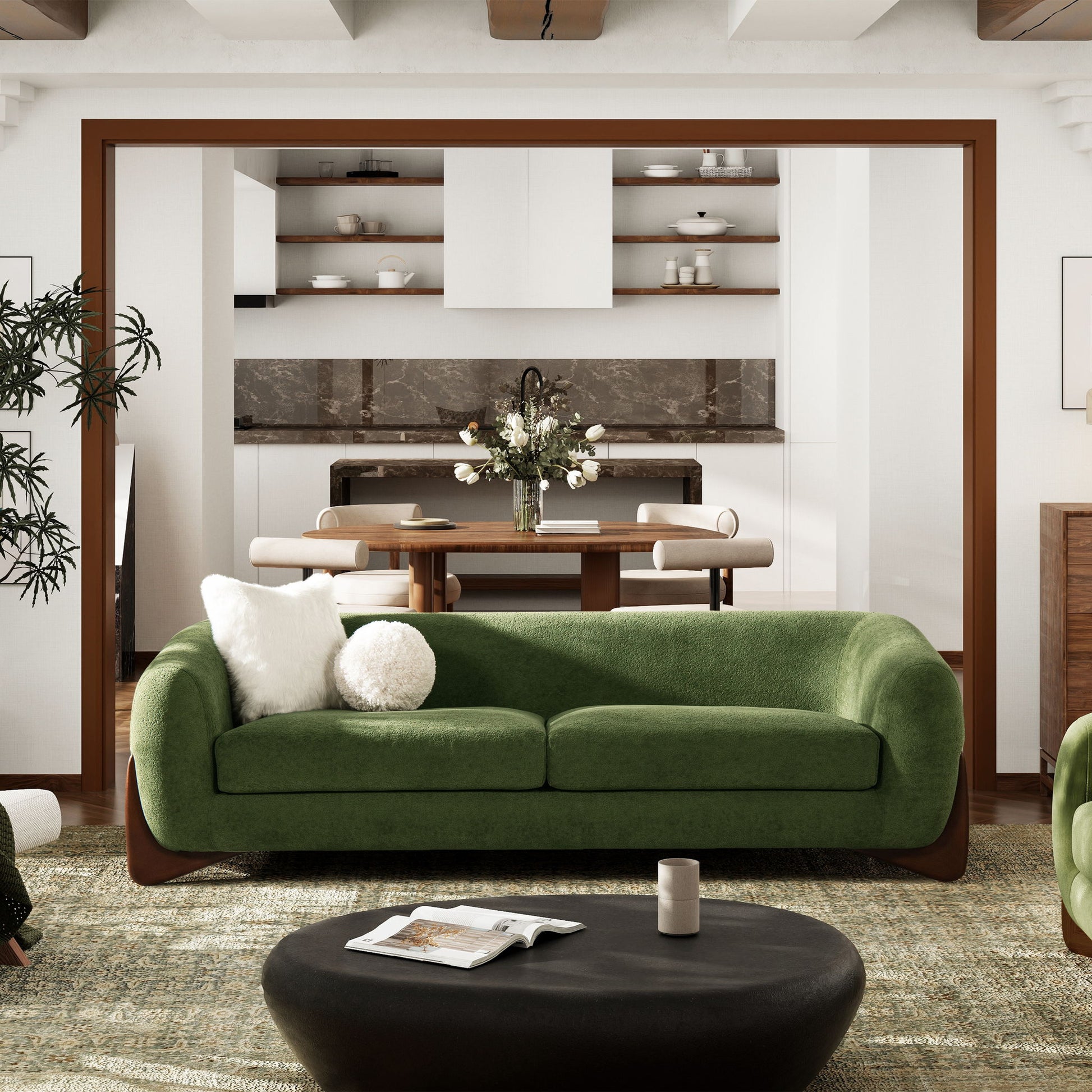 A modern living room features the Alpine Luxurious Upholstery Sherpa Sofa in green, complemented by a white pillow, a round black coffee table, and views into a kitchen with open shelves, marble backsplash, and a dining table with flowers.
