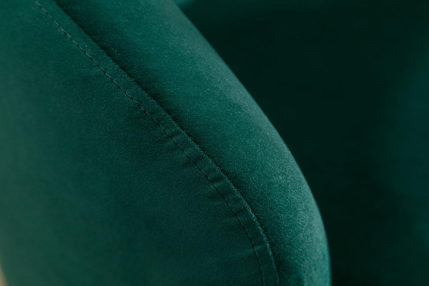 Close-up of the Velvet Fabric Swivel Accent Armchair Barrel Chair, highlighting the soft green velvet texture and detailed stitching along its curved armrest with a powder-coated metal ring.
