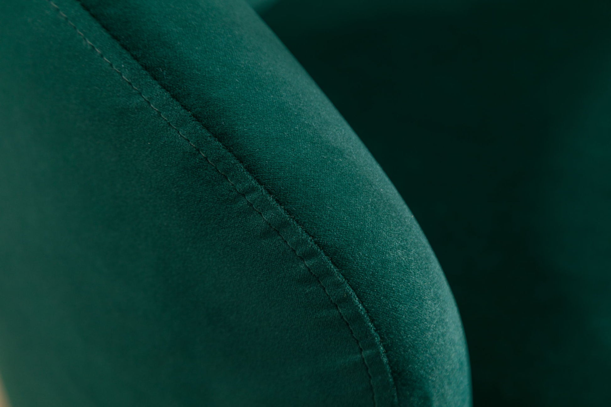 Close-up of the Velvet Fabric Swivel Accent Armchair Barrel Chair, highlighting the soft green velvet texture and detailed stitching along its curved armrest with a powder-coated metal ring.