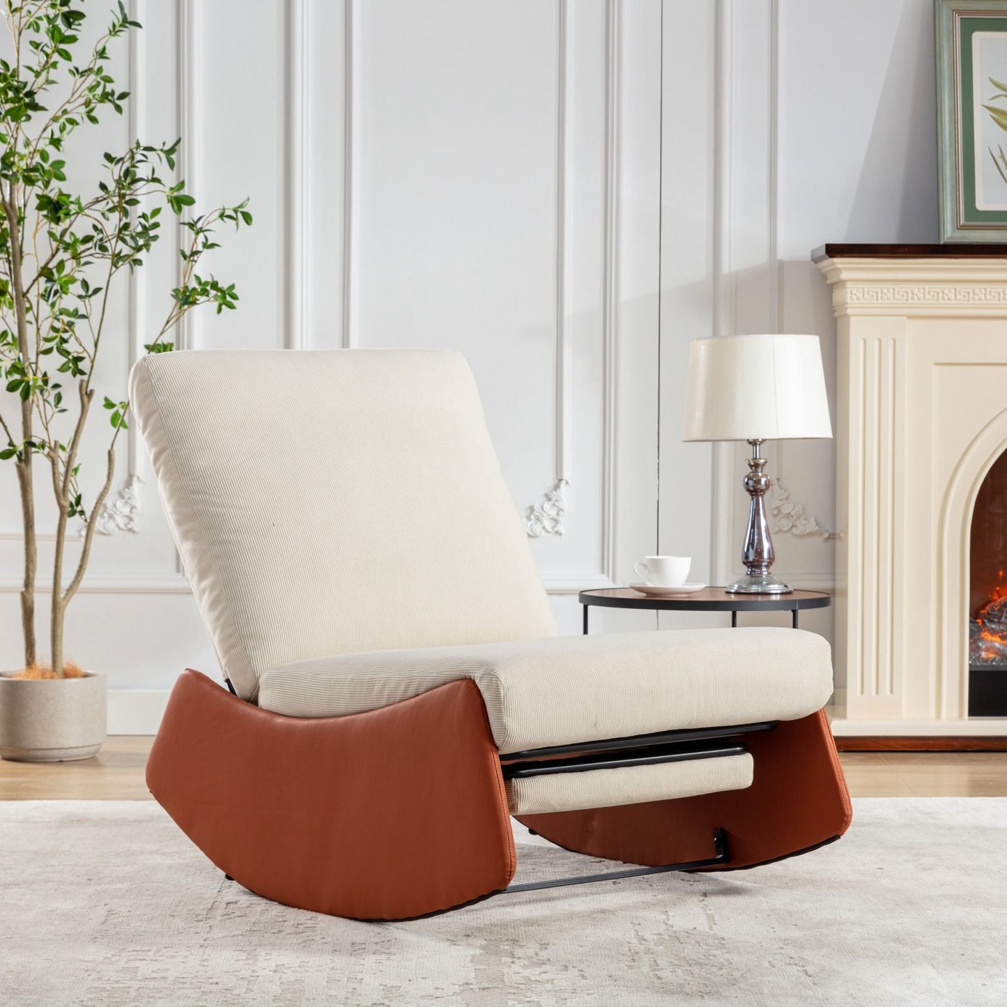 A Modern Rocking Chair Recliner with soft padding and footrest sits on a light rug in a stylish living room, next to a round side table with a lamp, a cup, fireplace, and tall indoor plant.