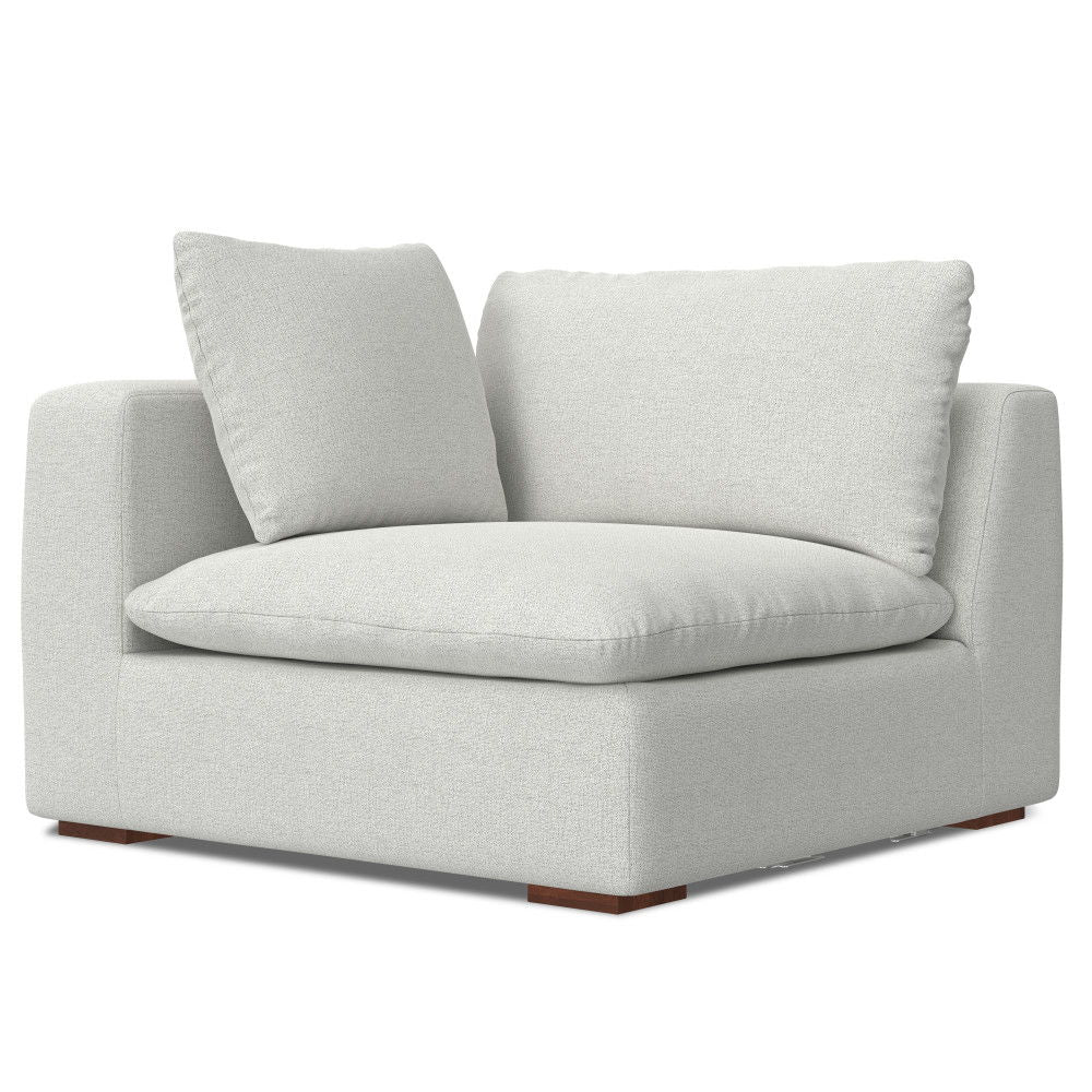 The Jasmine - Handcrafted Sofa features a modern design with light gray upholstery, plush seat and back cushions, square arms, and wooden block feet at each corner.
