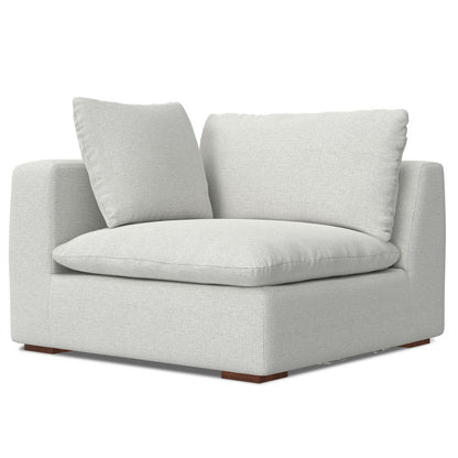 The Jasmine - Handcrafted Sofa features a modern design with light gray upholstery, plush seat and back cushions, square arms, and wooden block feet at each corner.