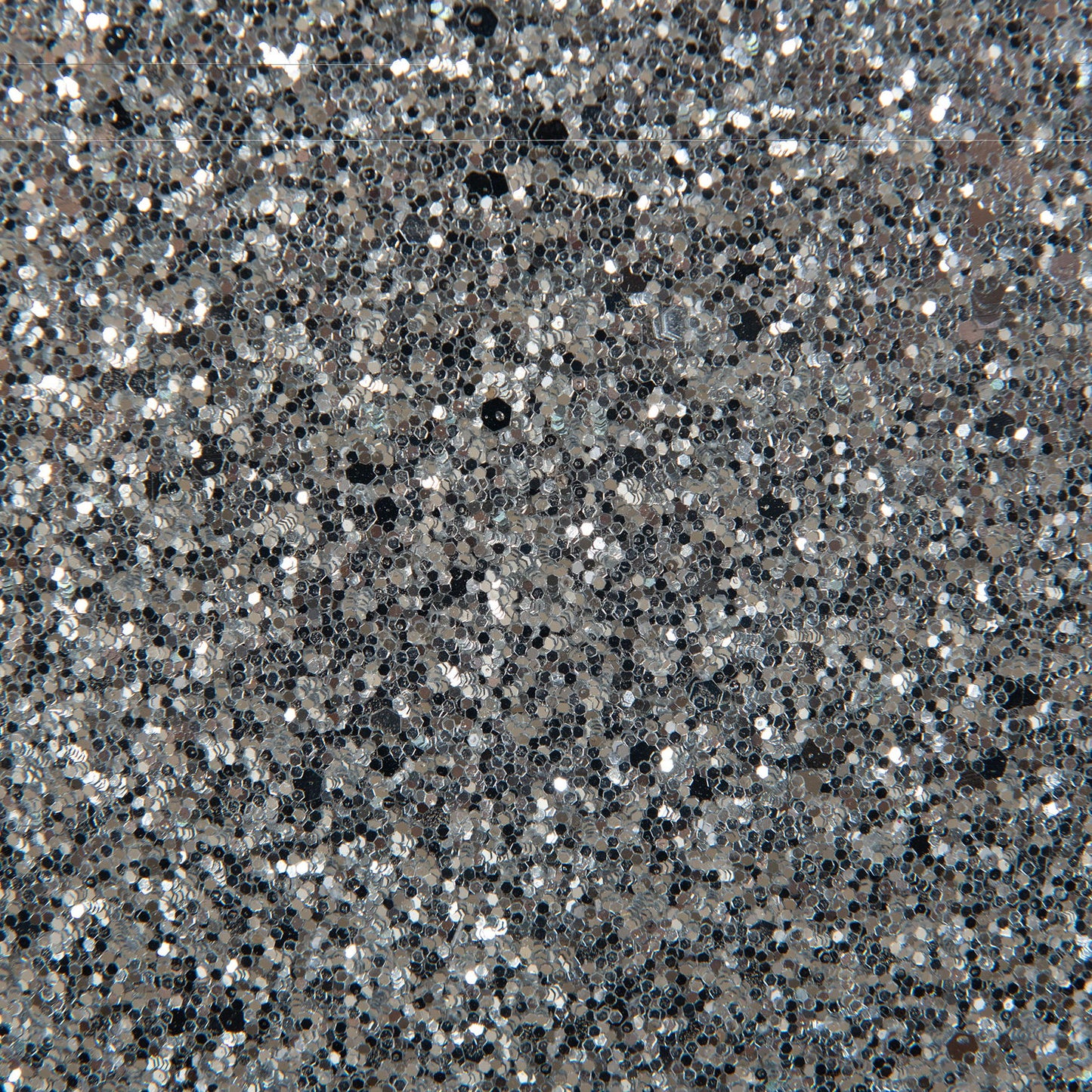 A close-up of the Couch.com Maloise Chest White shows its densely packed silver glitter surface, creating a sparkly, reflective look with shimmering light and dark areas. This wood chest features storage and a stylish gray finish.