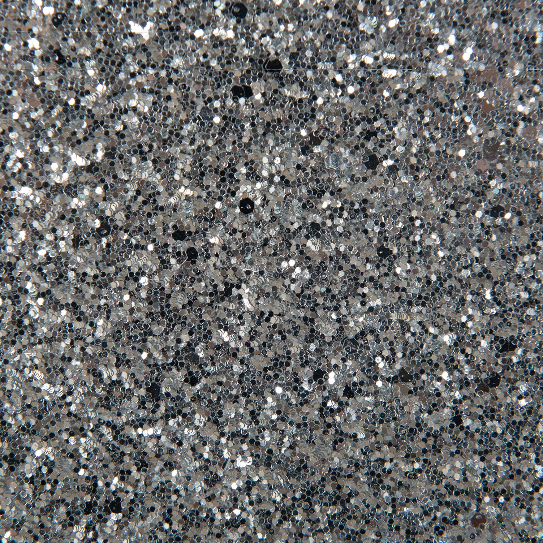 A close-up of the Couch.com Maloise Chest White shows its densely packed silver glitter surface, creating a sparkly, reflective look with shimmering light and dark areas. This wood chest features storage and a stylish gray finish.
