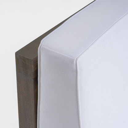 Close-up of a corner of the Oana Arm Chair, featuring a white, box-shaped cushion on a wooden frame, set against a plain white background.