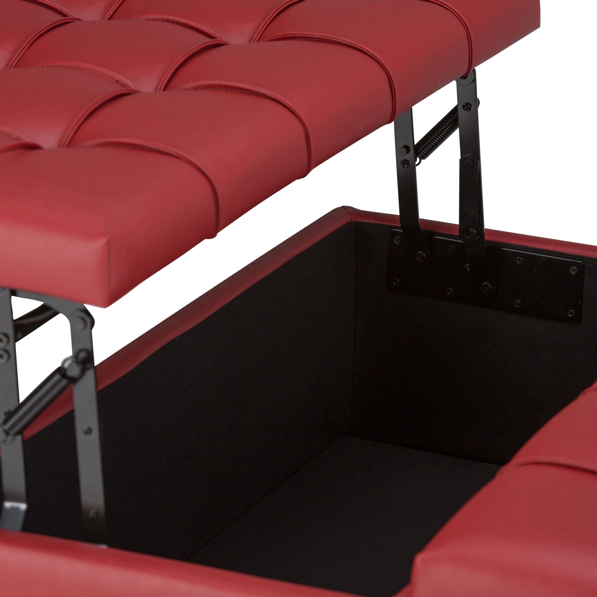 A close-up of the Harrison Upholstered Coffee Table Storage Ottoman shows its red tufted cushioned lid open, revealing a spacious black storage compartment inside, supported by sturdy metal hinges.