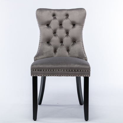 The Nikki chair set features modern, high-end velvet upholstery, a tufted backrest, silver nailhead trim, and dark wood legs—perfect for contemporary dining rooms.
