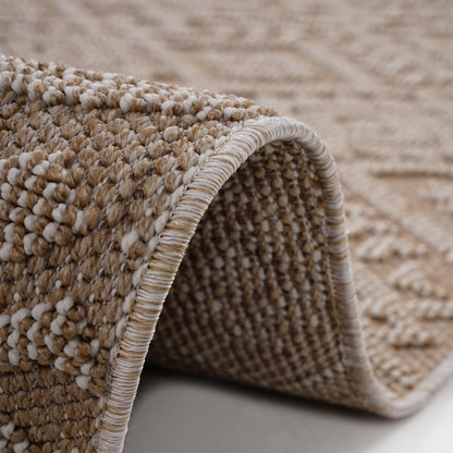 Close-up of the Guros - Traditional Indoor / Outdoor Area Rug in beige and cream, with a curved edge lifted to reveal its detailed textured patterns and stitched border.