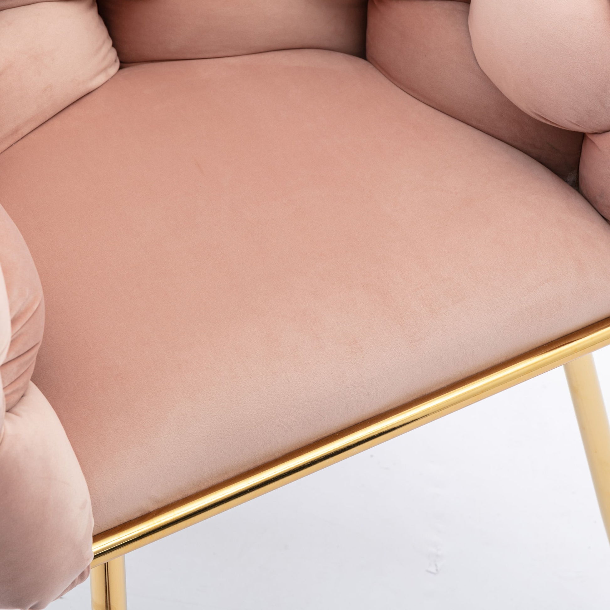 Close-up of the Luxury Modern Simple Leisure Velvet Single Sofa Chair in light pink, featuring cushioned armrests and a gold metal frame and legs, set against a white background. Ideal for bedroom, dresser, or manicure table use.