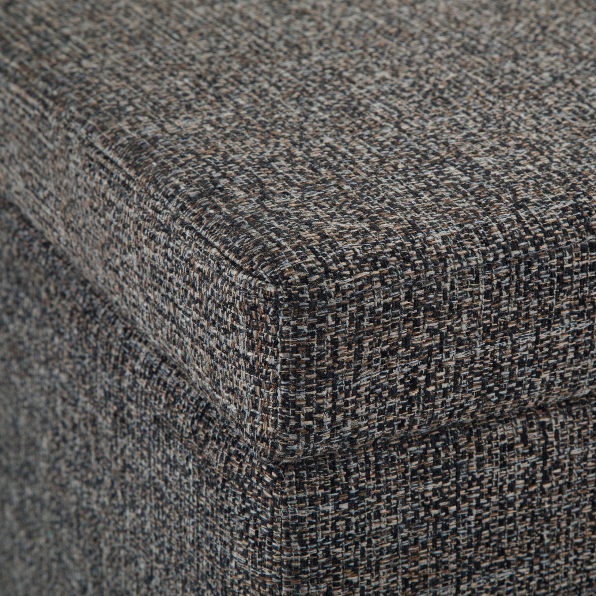Close-up of the corner of the Avalon Storage Ottoman Bench in dark gray, featuring textured, speckled fabric and detailed weave on the upholstered surface.
