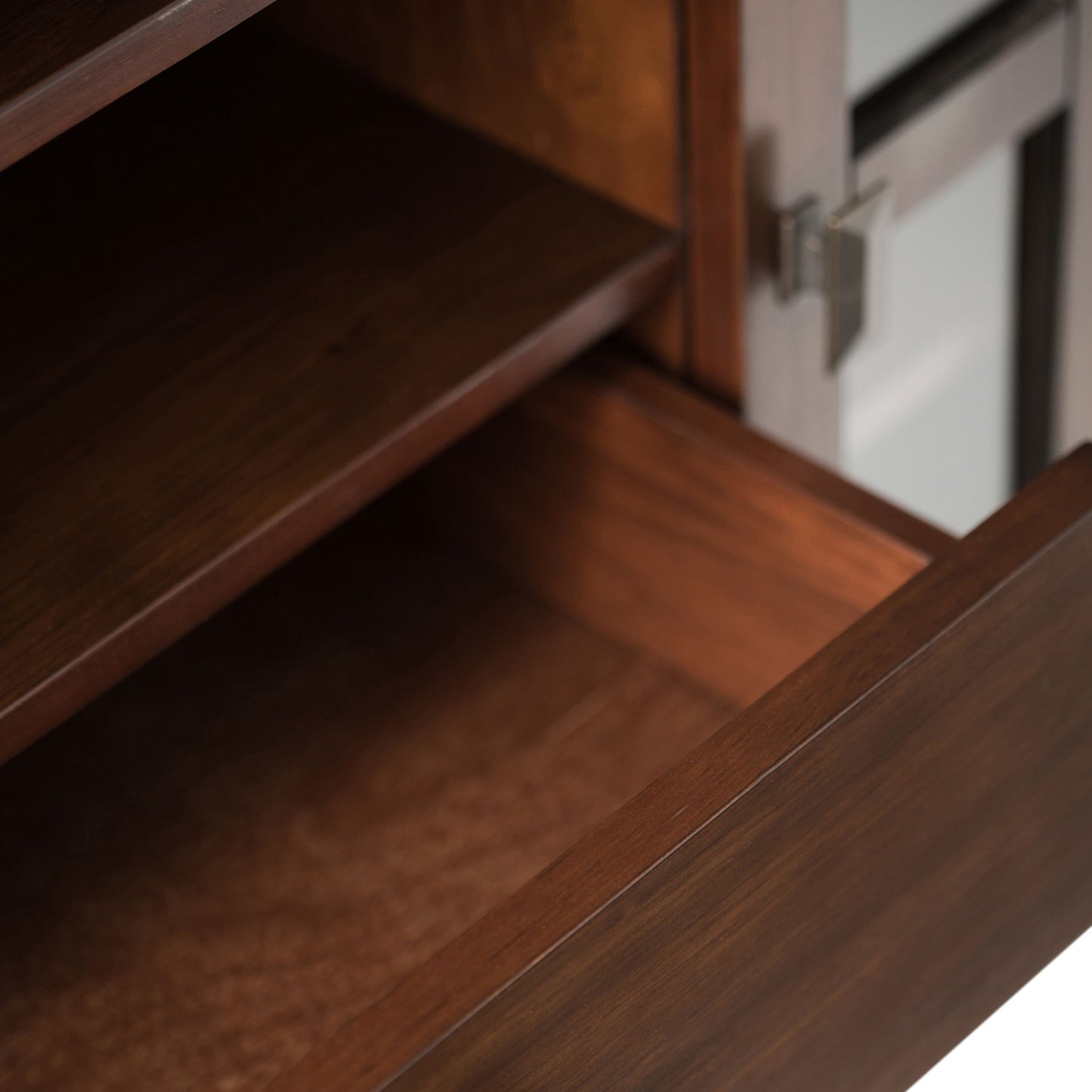 Close-up of an open wooden drawer and shelf with a dark brown finish on the Artisan - Handcrafted, Tall TV Media Stand, featuring a metallic handle and a glass panel on the right side.