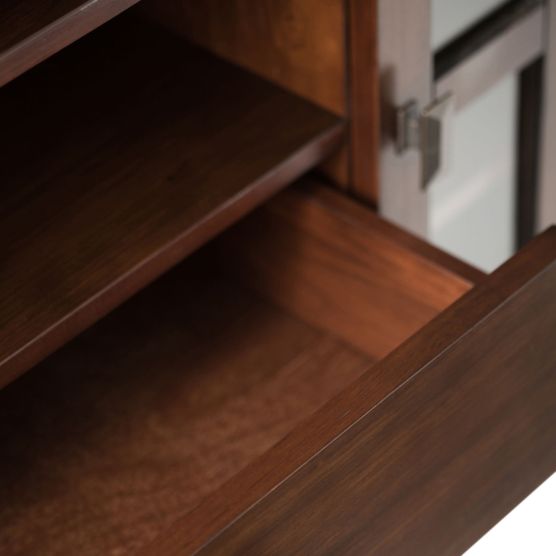Close-up of an open wooden drawer and shelf with a dark brown finish on the Artisan - Handcrafted, Tall TV Media Stand, featuring a metallic handle and a glass panel on the right side.
