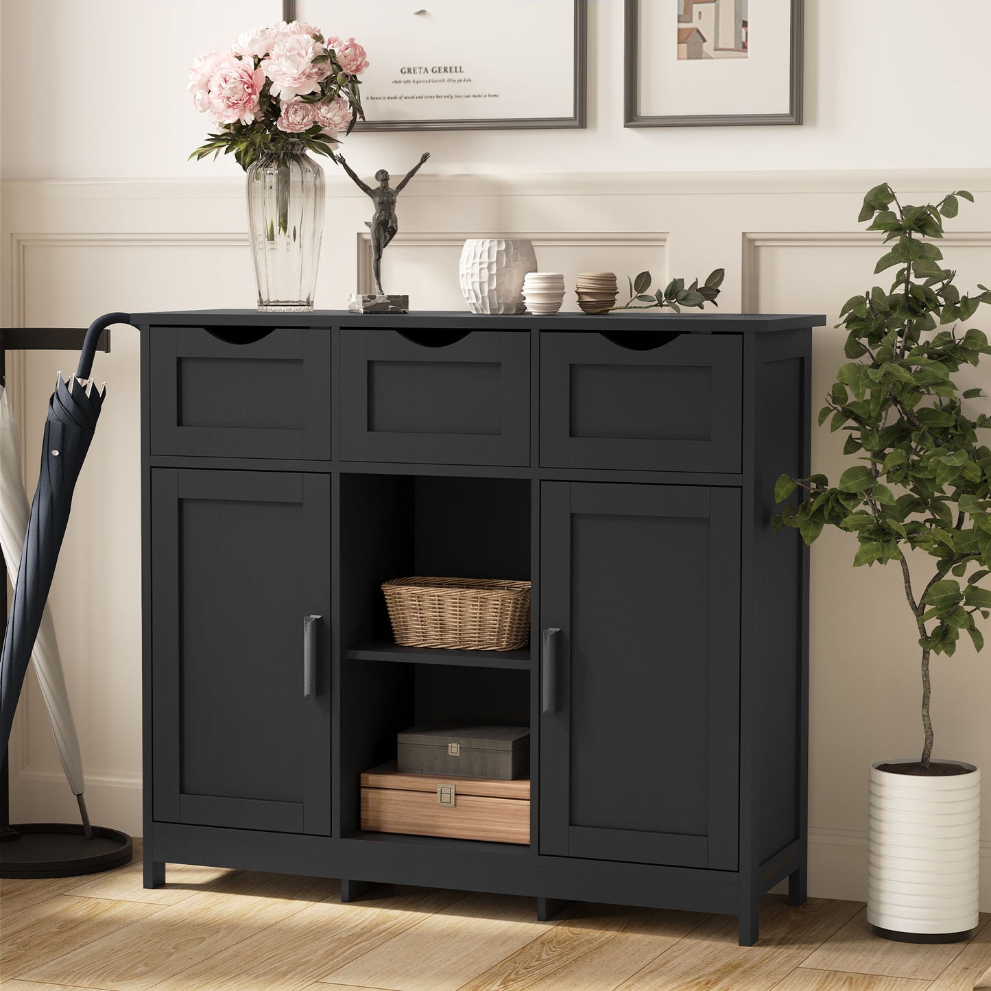 A Storage Cabinet with drawers and shelves stands by the wall, topped with a vase of flowers, a sculpture, and framed photos. Baskets and boxes are neatly placed below. Perfect as an accent cabinet for your living room, bedroom, or bathroom.