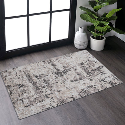 The Payas - Abstract Area Rug, featuring a beige and gray textured design, is placed on dark wood flooring near a large window, accompanied by a green potted plant and a white decorative vase in the corner.