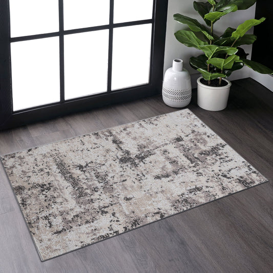 The Payas - Abstract Area Rug, featuring a beige and gray textured design, is placed on dark wood flooring near a large window, accompanied by a green potted plant and a white decorative vase in the corner.