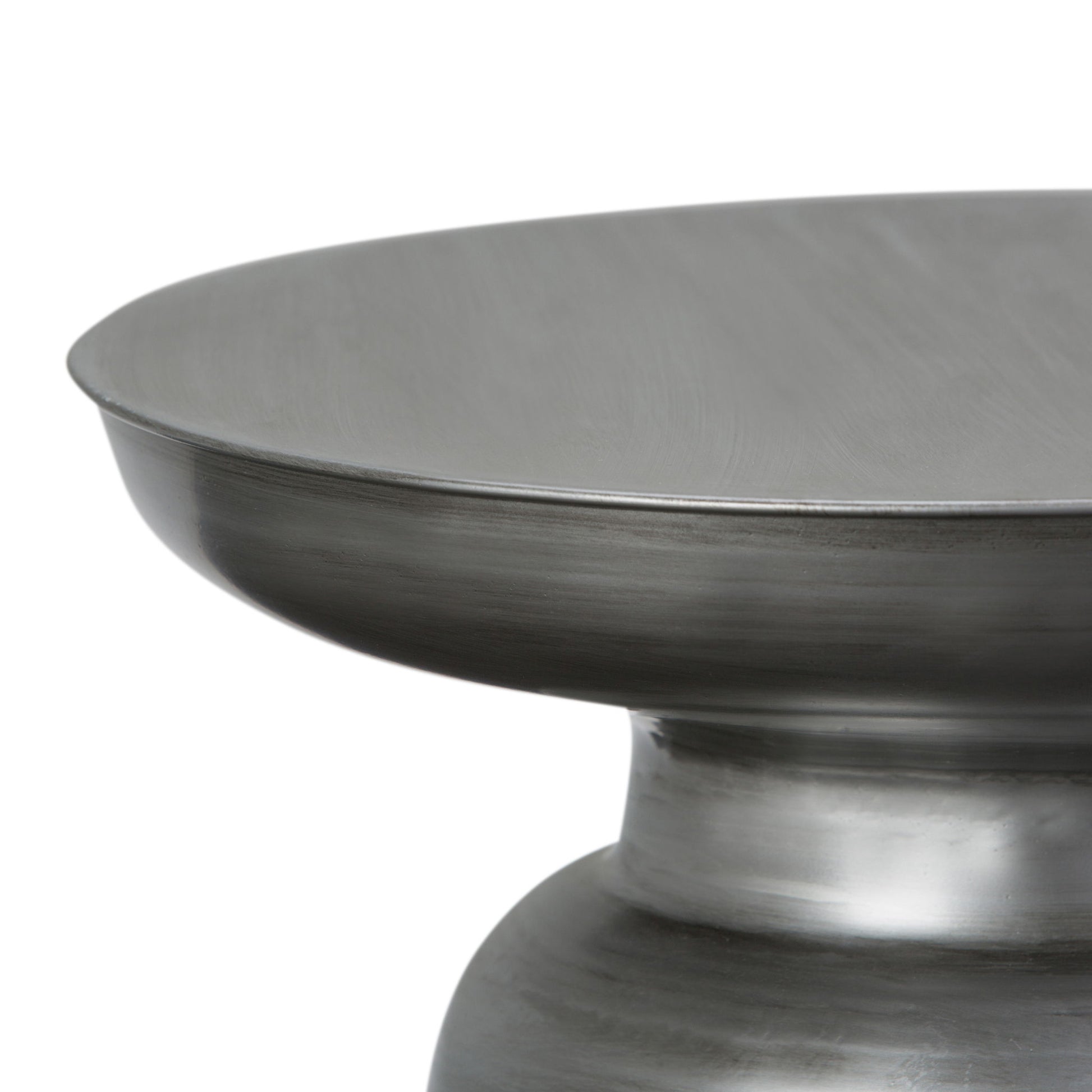 Close-up of the upper section of the Toby - Handcrafted Metal Accent Table, featuring a wide, flat top and a rounded, tapered base with a brushed steel finish.