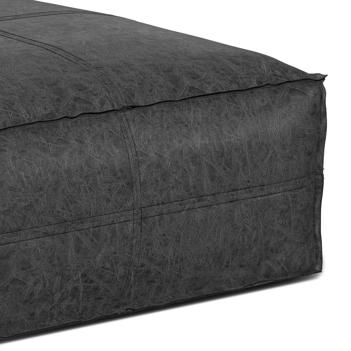 Close-up of the corner of the Brody Large Square Coffee Table Pouf, featuring dark gray textured fabric, visible stitching, and a slightly wrinkled surface.