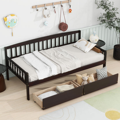 A Pine Wood Daybed with two storage drawers and a 10-slat bed platform sits in a bright, playfully decorated room with light walls, toys and pillows in the drawers, and a green plant in the corner.