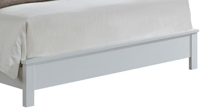 A close-up of the footboard of the Transitional Modern Design Bed, a white wooden frame topped with a light-colored blanket and comforter.