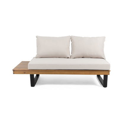 The Sebastian 2 Seater Sofa features beige cushions, a wooden seat, black metal legs, and an integrated wooden side table on the left for modern outdoor lounging.