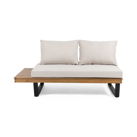 The Sebastian 2 Seater Sofa features beige cushions, a wooden seat, black metal legs, and an integrated wooden side table on the left for modern outdoor lounging.