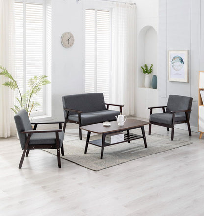 The Bahamas - Living Room Set features light wood flooring, gray upholstered sofa and chairs, a wooden coffee table with tea set, white walls, a plant, clock, and sunlight streaming through tall windows with blinds.