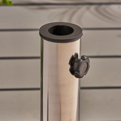 A close-up of the Wheelie - Round Umbrella Base With Stainless Steel Holder featuring a black plastic tightening knob, set against a light gray slatted background.
