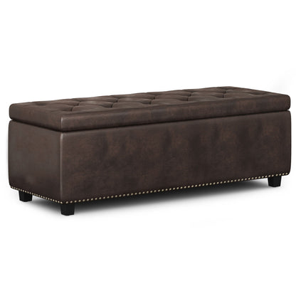 The Hamilton Upholstered Storage Ottoman features a rectangular, dark brown leather design with a tufted lift-top for storage, nailhead trim at the base, and short black legs.