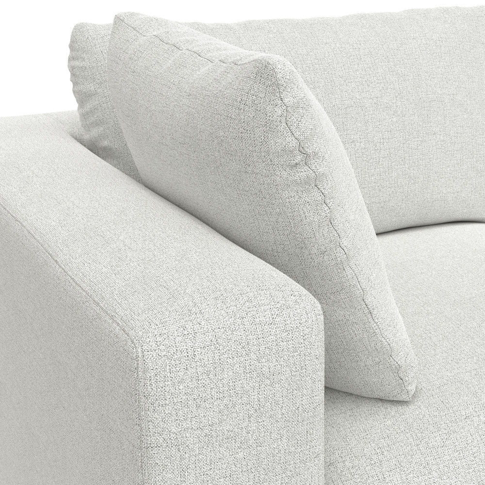Close-up of the Jasmine - Handcrafted Sofa and Ottoman in light gray, featuring a thick armrest, backrest, and a plush square back cushion.