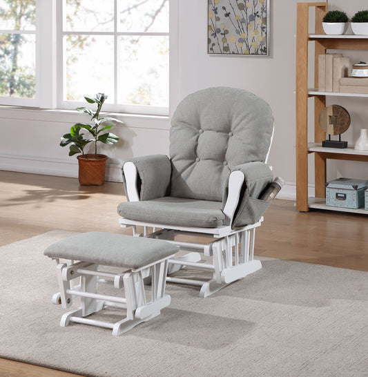 The Mason - Glider and Ottoman White Wood, featuring gray cushions, sits on a beige rug in a bright living room with wooden floors, large windows, shelves, and a plant in the background.