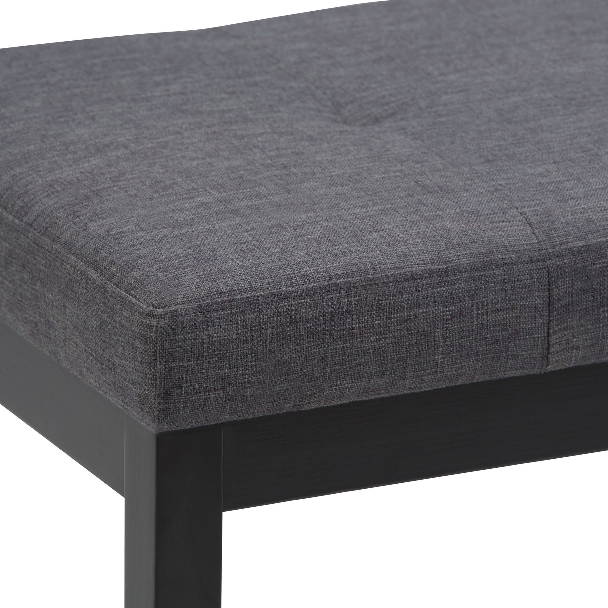 Close-up of the Lacey - Upholstered Tufted Ottoman Bench featuring a dark gray textured fabric seat with visible stitching and black wooden legs.