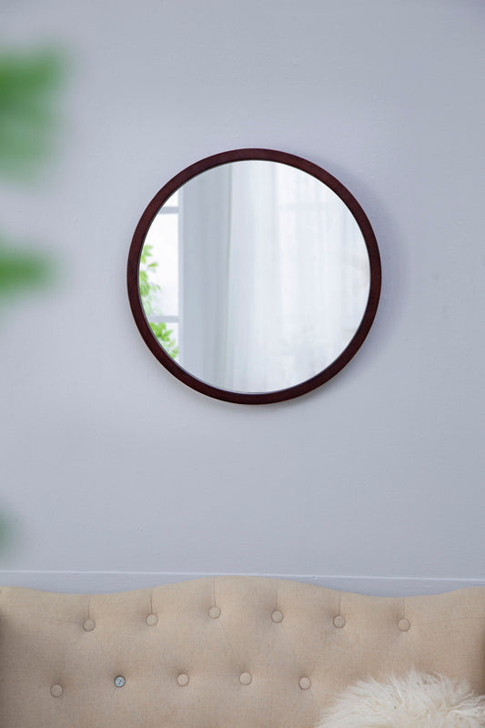 The Circle Wall Mirror With Wooden Frame, Wall Mirror For Living Room, hangs above a beige tufted sofa, reflecting a window with sheer white curtains and a glimpse of greenery outside.